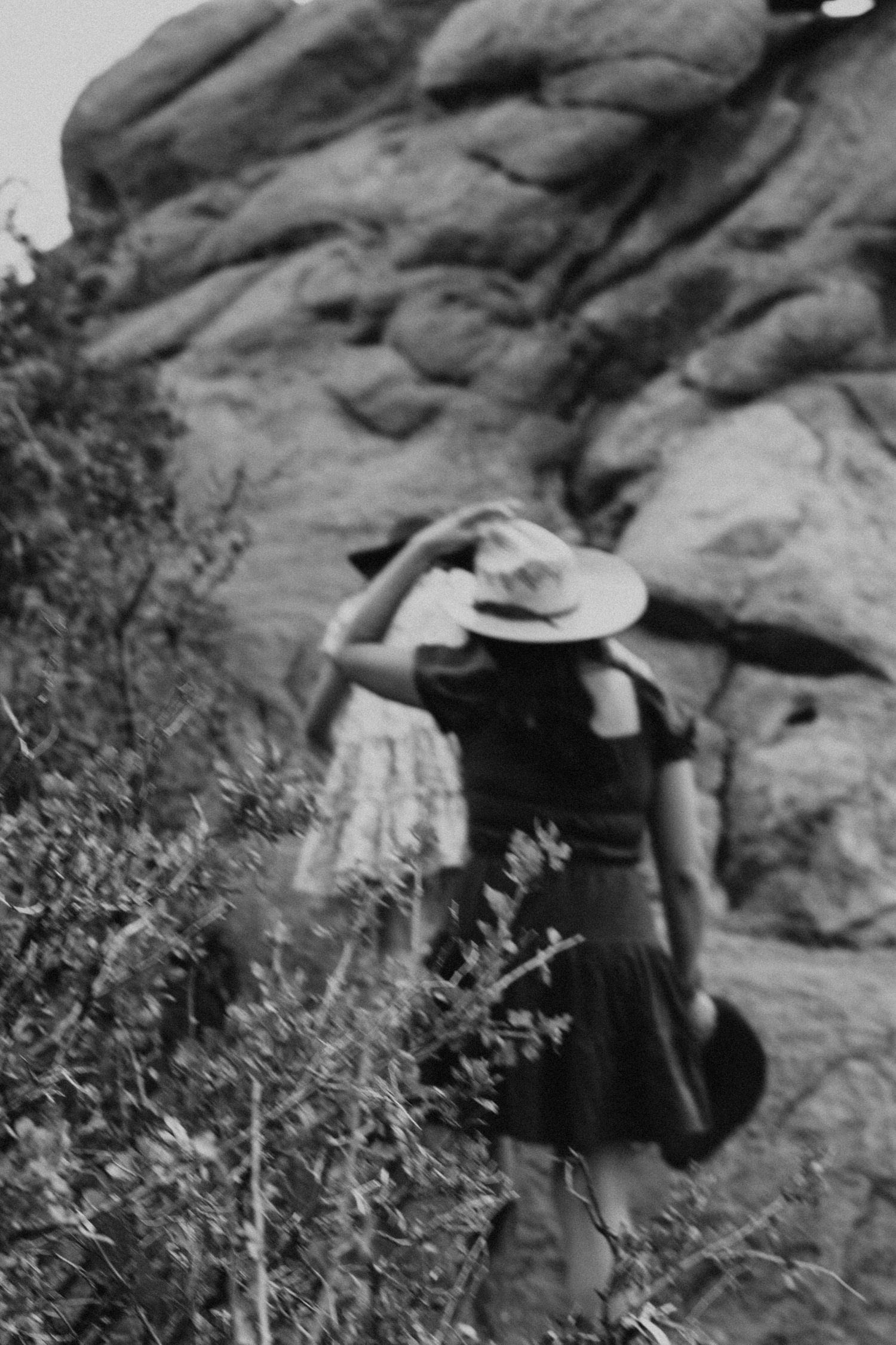 Colorado Springs adventurers exploring rocky terrain wearing hats and carrying backpacks from traveling photographer.