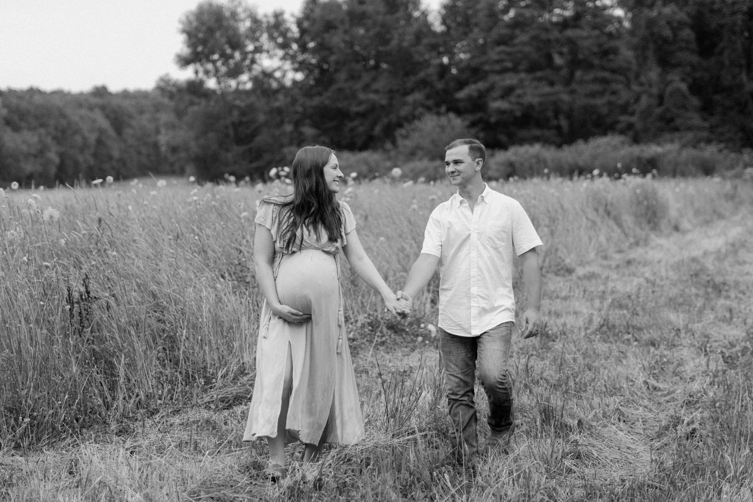 Couple sitting together in a serene meadow landscape.