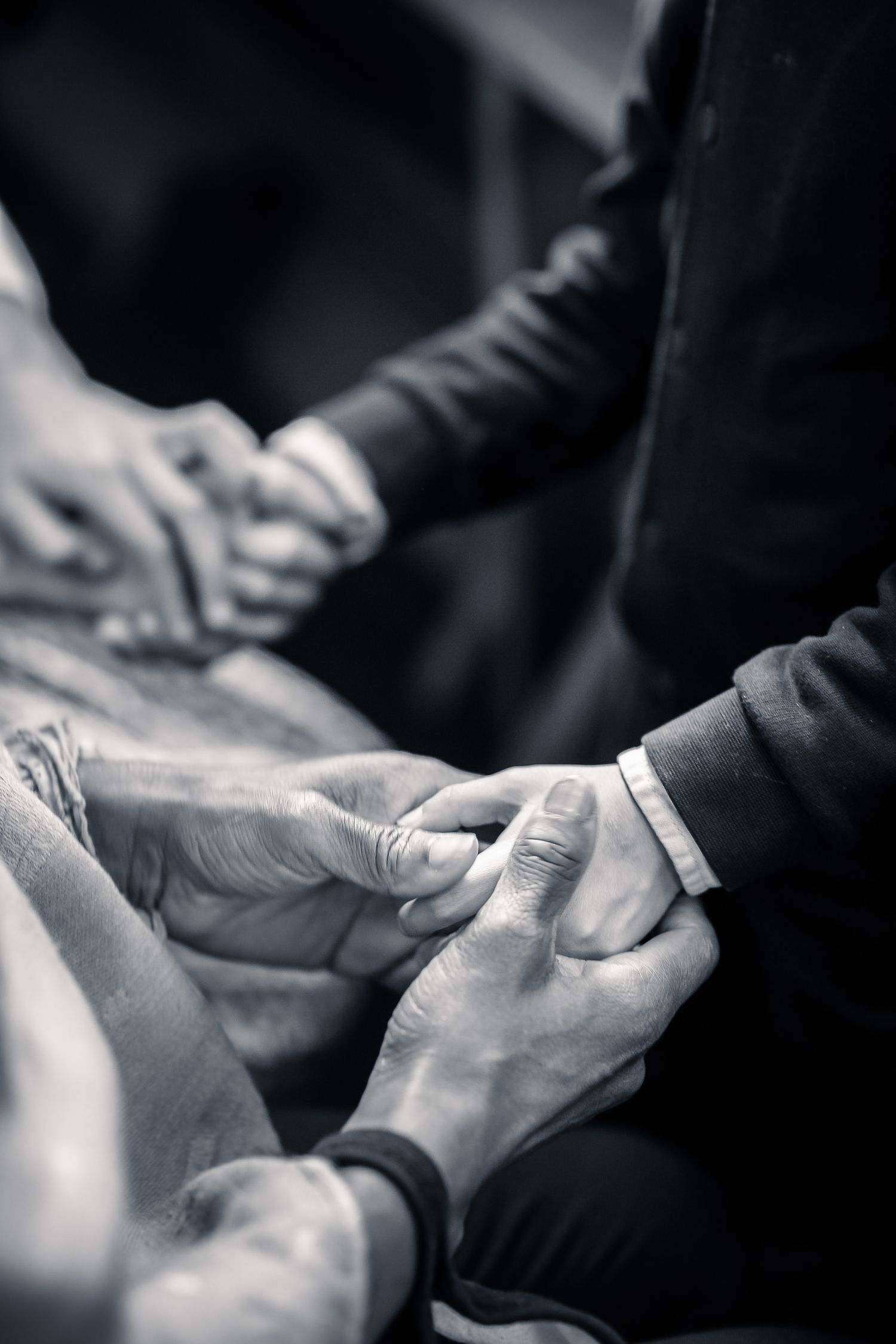 Close-up black and white shot of hands holding during an intimate moment.