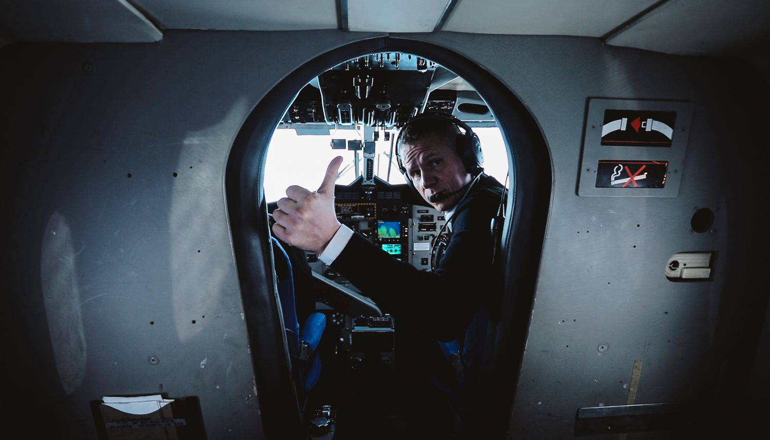 Split pilot looks back from cockpit giving the thumbs up
