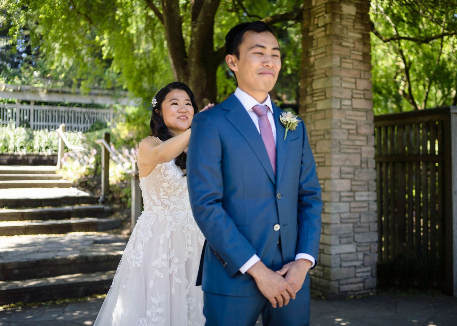Outdoor wedding portrait by stone pillars and garden staircase.