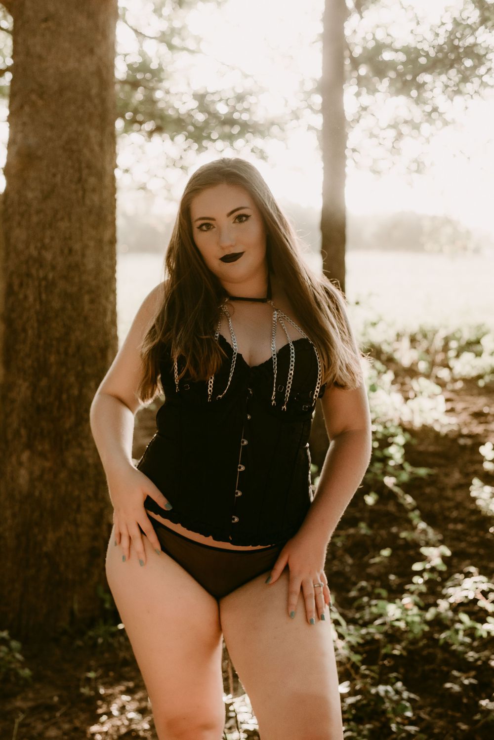 Body positive fashion photography in natural woodland setting with warm lighting.