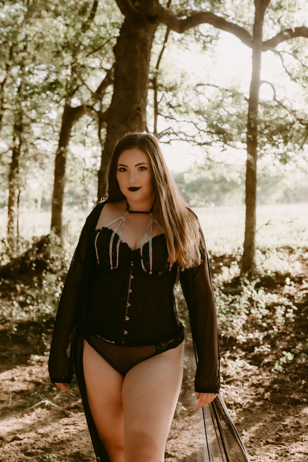 Autumn woodland fashion portrait with black corset and dramatic lighting.