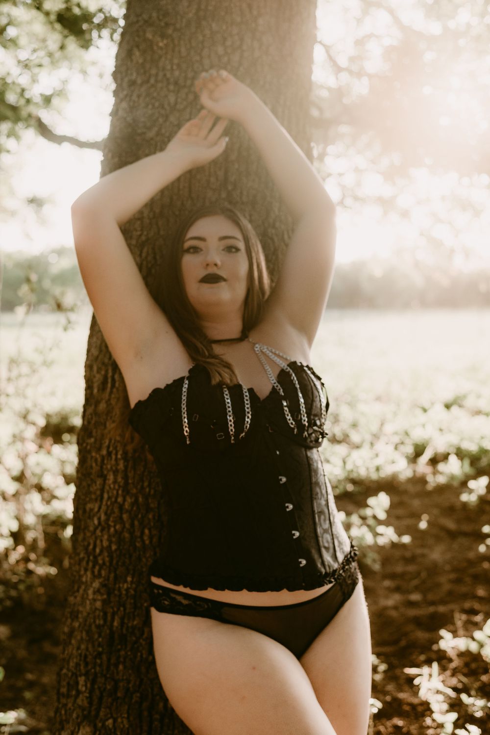 Forest fashion portrait with sepia tones and gothic styling against natural backdrop.
