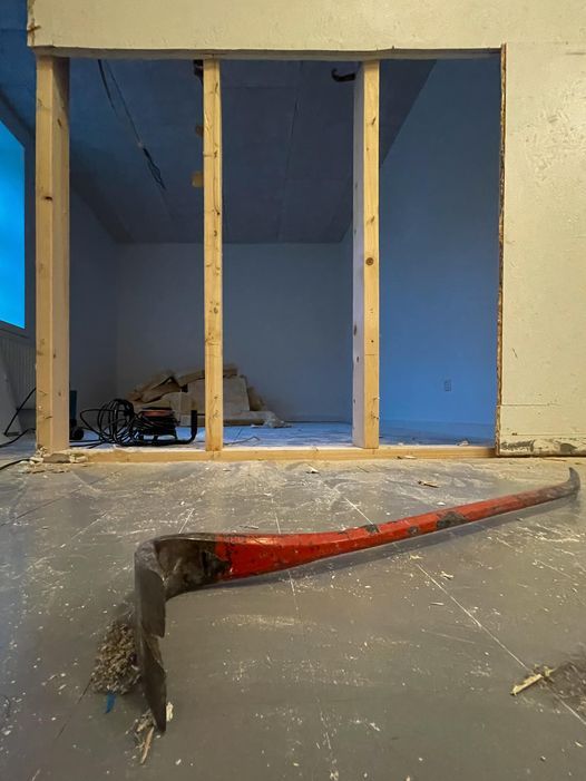Empty basement or garage space with wooden support beams and blue walls.