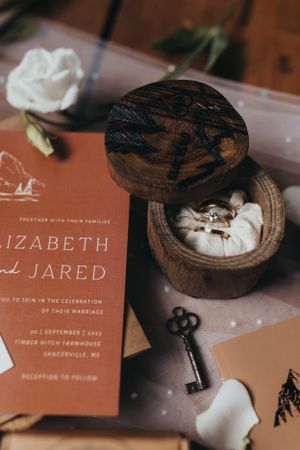 Wedding invitation suite in terracotta colors with wooden ring box.