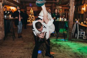 Wedding reception dance floor moment with dramatic lighting in rustic barn venue.