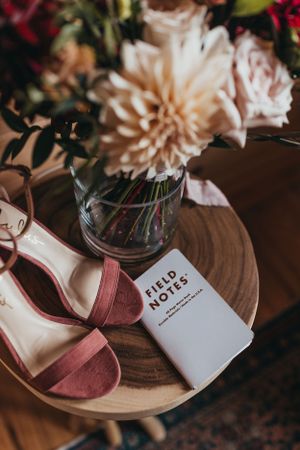 Field Notes notebooks and floral arrangements on wooden table with soft lighting.
