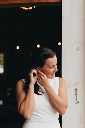 Elegant bridal portrait against white column with soft lighting.