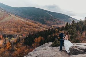 Scenic mountain overlook with fall foliage and lake view.