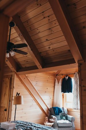 Interior of a rustic wooden cabin with exposed beams and vaulted ceiling.