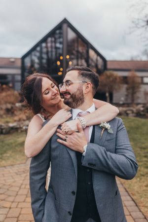 A romantic outdoor wedding portrait with couple embracing on stone pathway.