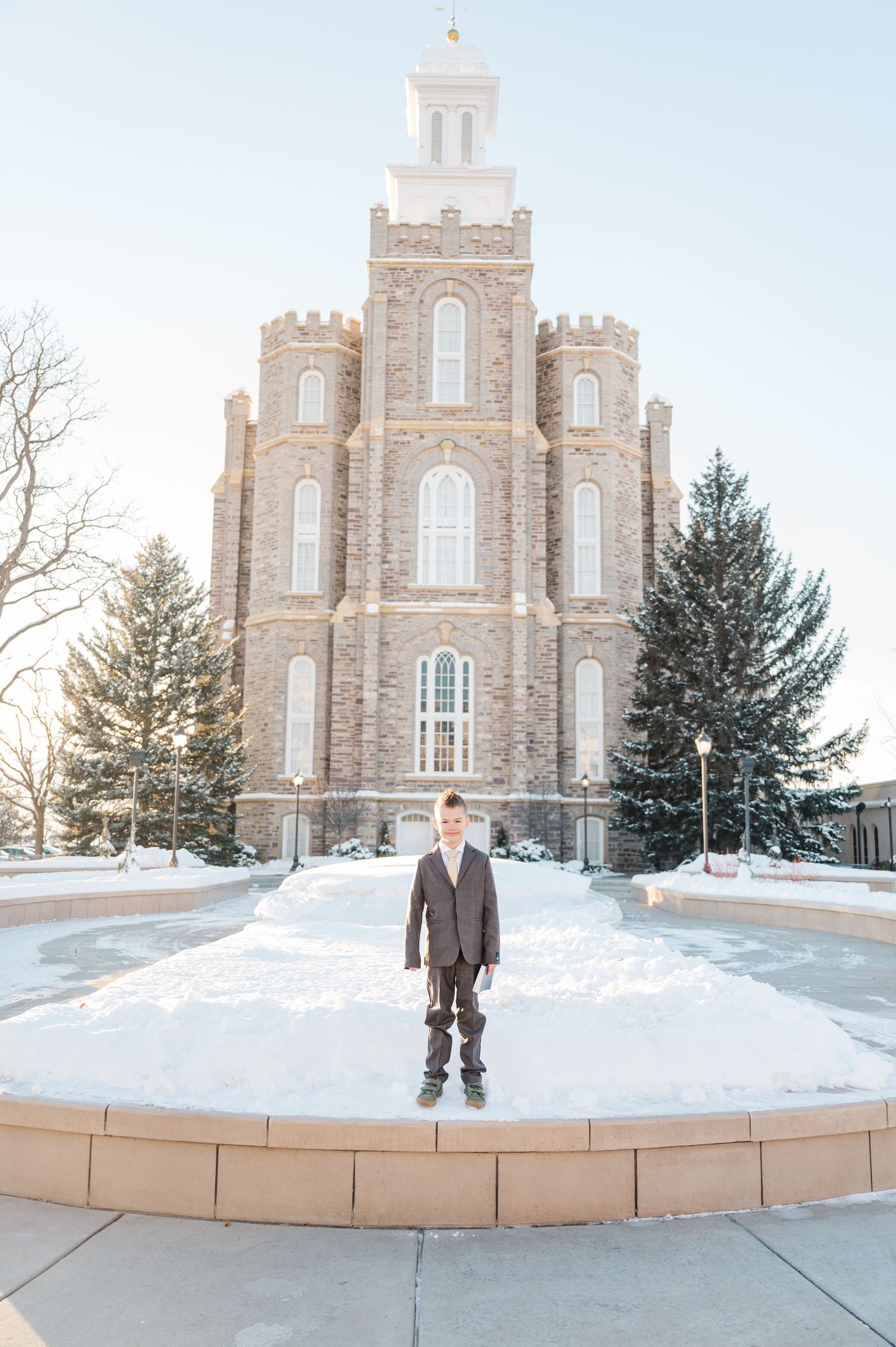 A grand stone temple with spires stands tall against a winter sky with snow on the ground.