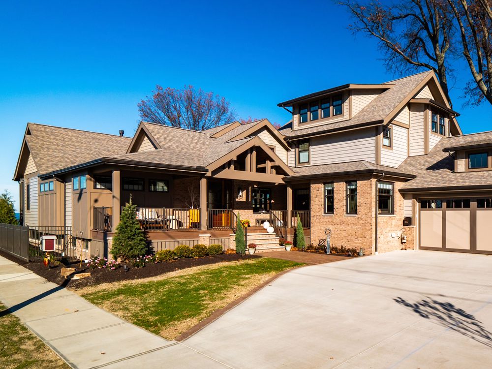 Craftsman style two-story home with covered porch and attached garage in natural setting.