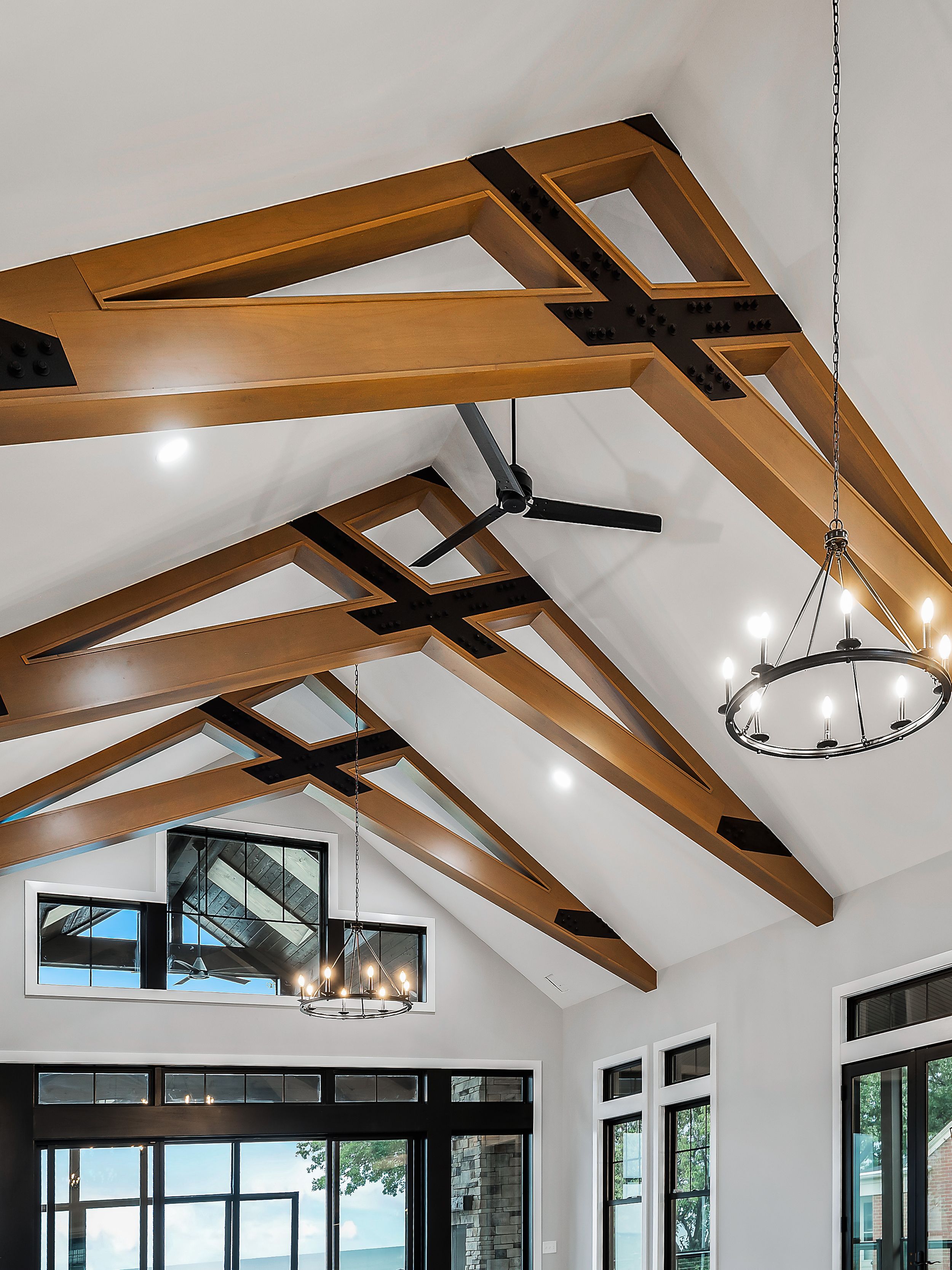 Vaulted ceiling with exposed wooden beams and modern chandelier in an elegant great room.