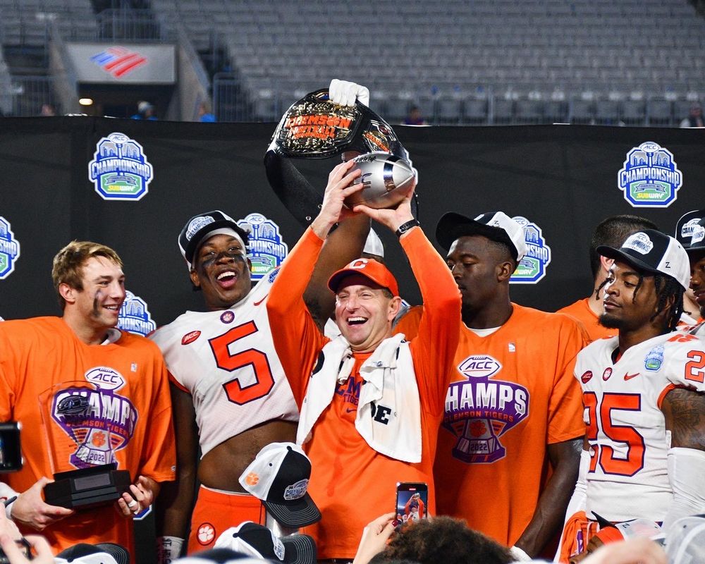 Clemson football team celebrates with trophy after winning bowl game.