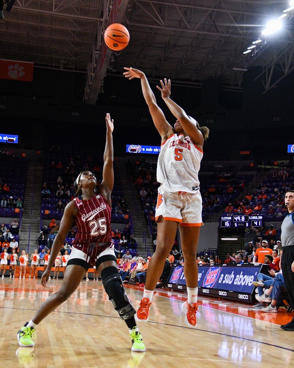 Basketball players competing for shot during intense game action.
