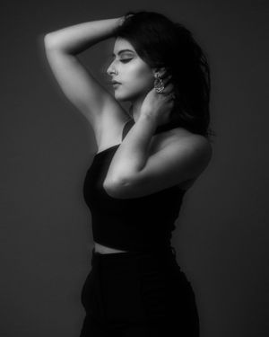 Dramatic black and white fashion portrait with model in black outfit.