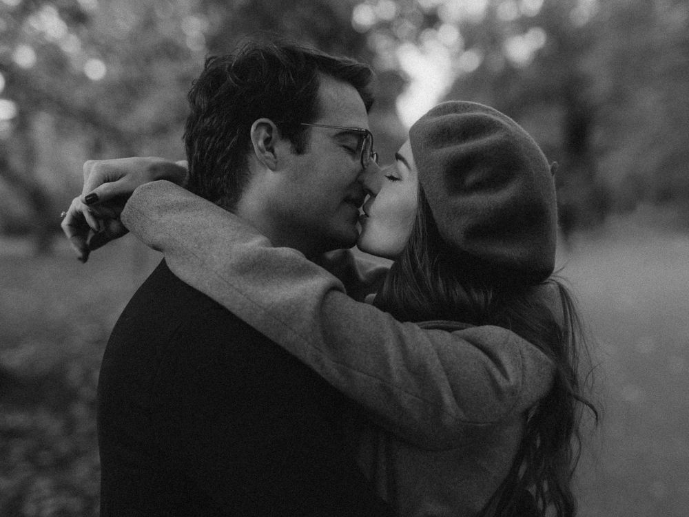 Black and white intimate portrait of a couple sharing a romantic kiss.