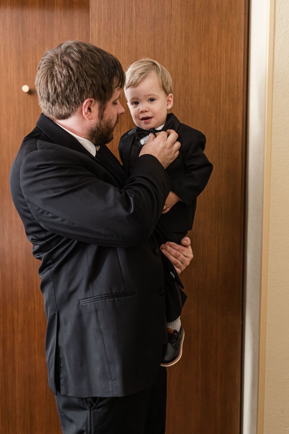 Touching moment of formal dress adjustment between parent and child.
