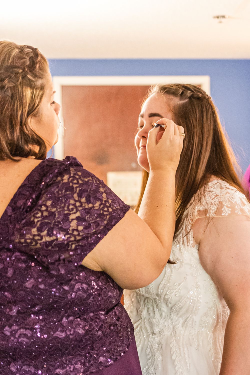 Wedding preparation scene with final makeup touches being applied.