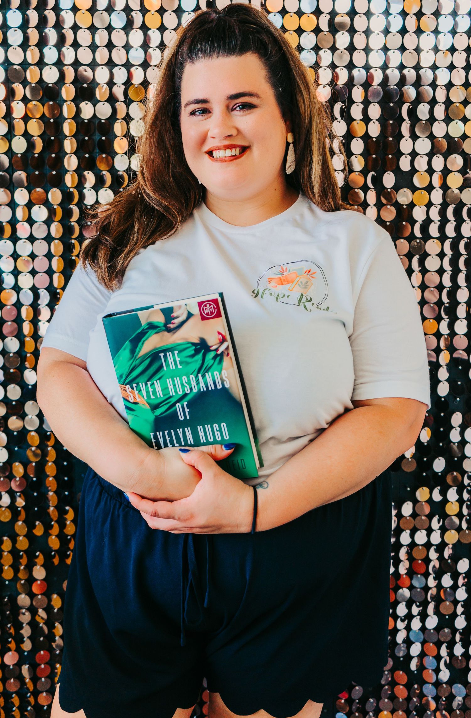 Outdoor Headshot Session in St. Pete, FL; Woman posing with book in front of penny wall