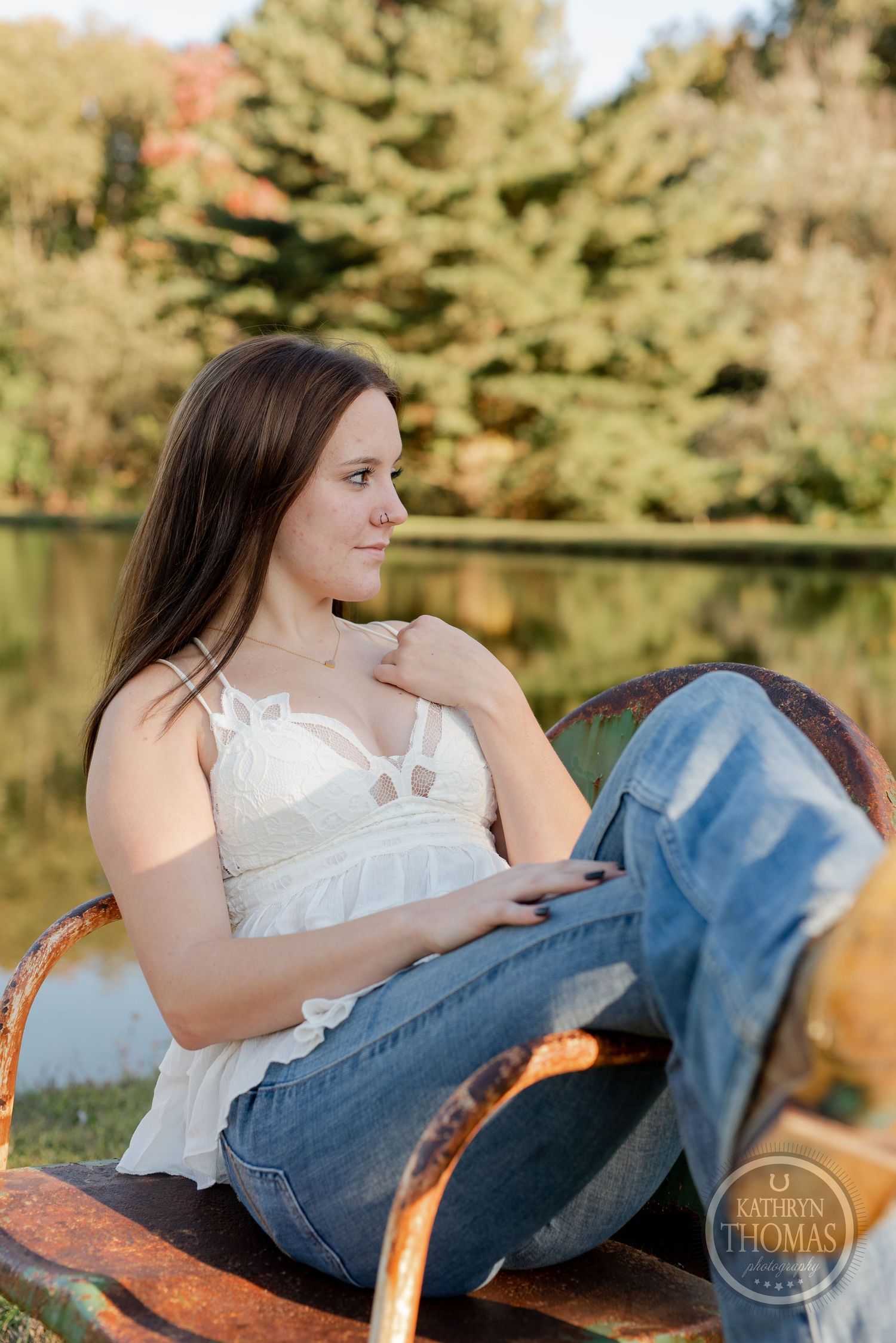 A relaxed outdoor scene with someone wearing a white top and jeans posed on vintage leather furniture.