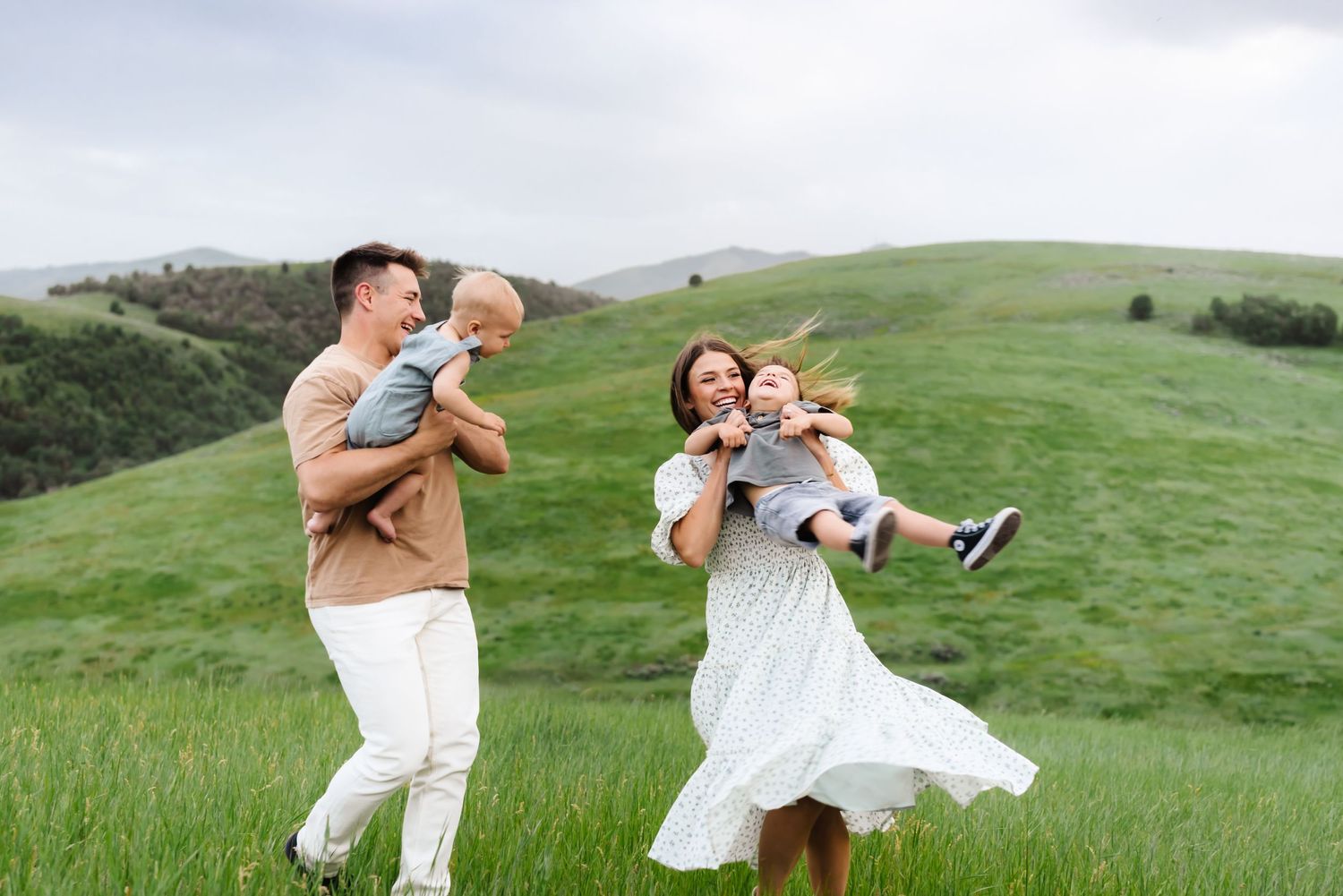 Playful family moments captured in a series of photos on rolling green hills.