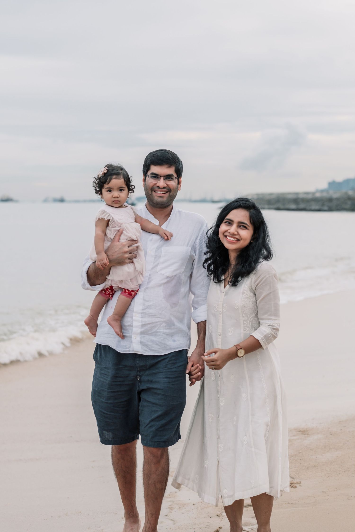 Family enjoying time together at beach with water view.