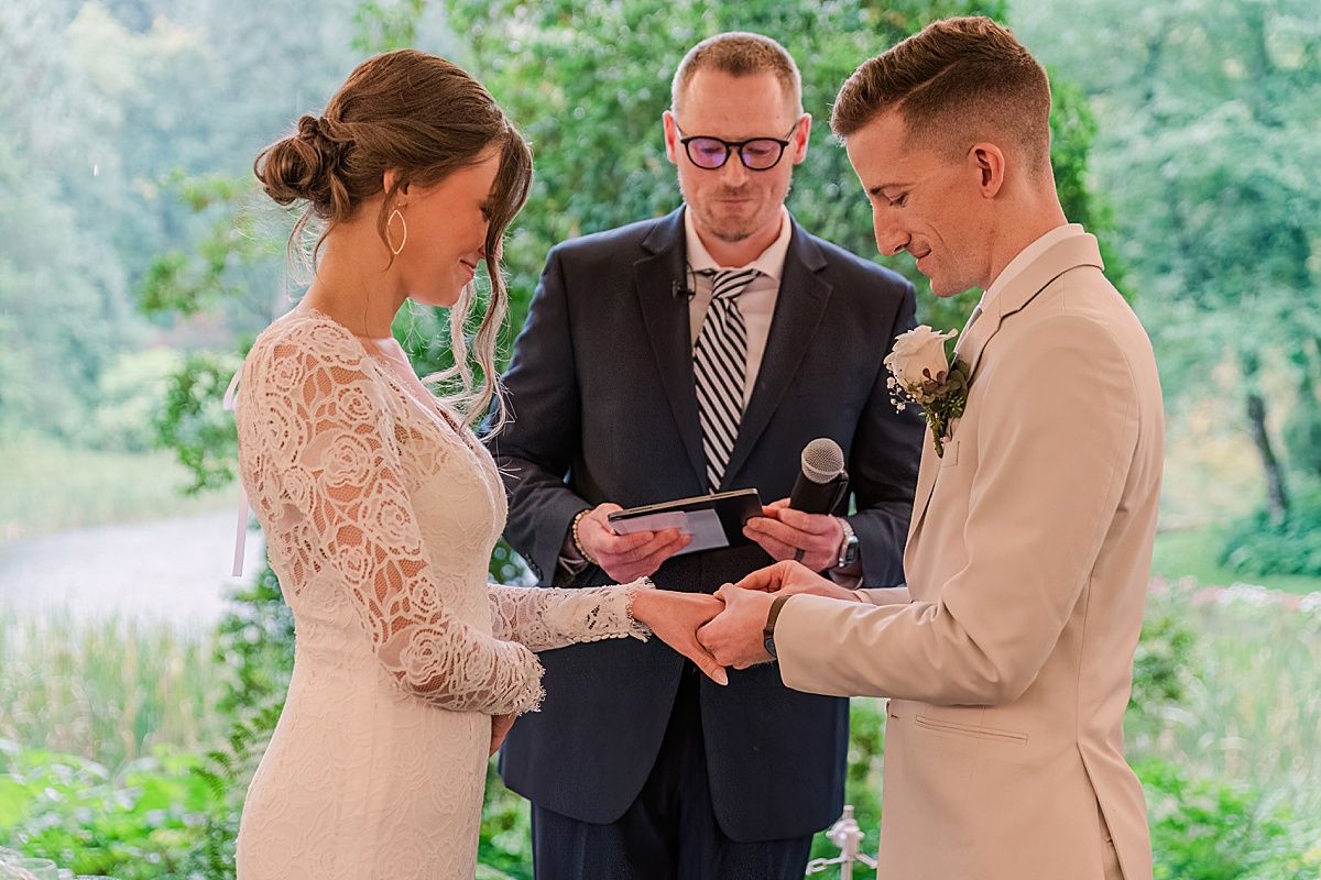 Photographer captures bride and groom exchanging rings during wedding ceremony