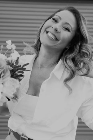 Black and white portraits capturing genuine laughter and joy with flowers.