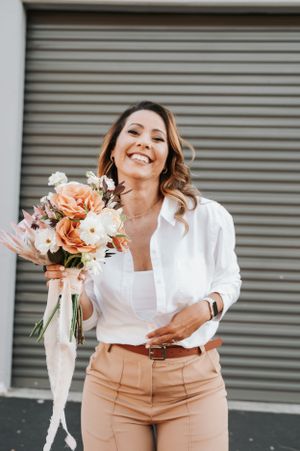 A joyful moment captured with a beautiful bouquet of pink and peach flowers against an industrial backdrop.