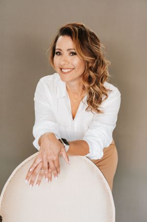 Studio portraits showing natural expressions while leaning on white furniture.