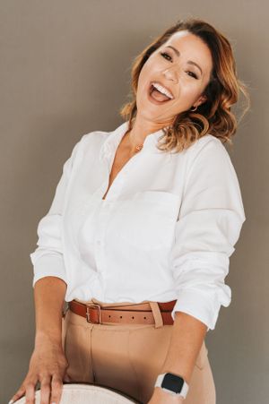 Fashion portraits in white top and tan pants with brown leather belt.
