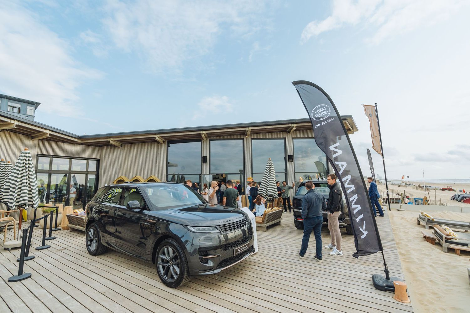 Black SUV displayed at an outdoor dealership event with people gathering around.