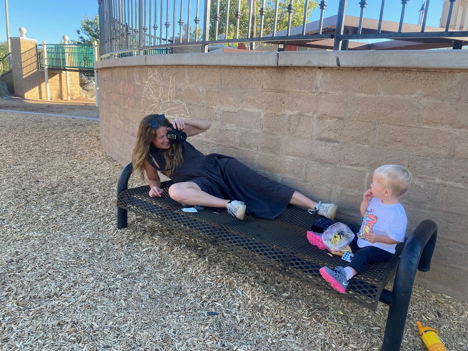 Auckland documentary photographer in action, taking a photo of a toddler at a playground.