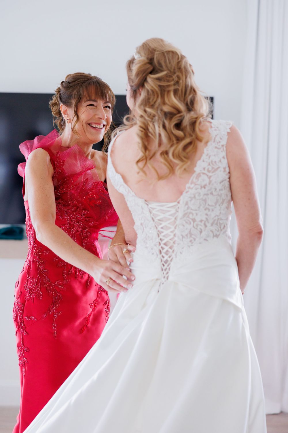 A touching moment between two people during wedding preparations in a bright modern room.
