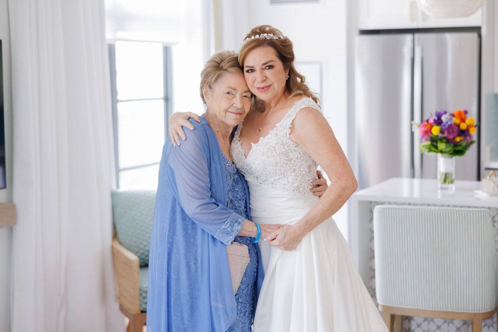 A bridal party in jewel-toned dresses gathered together in a bright modern room.