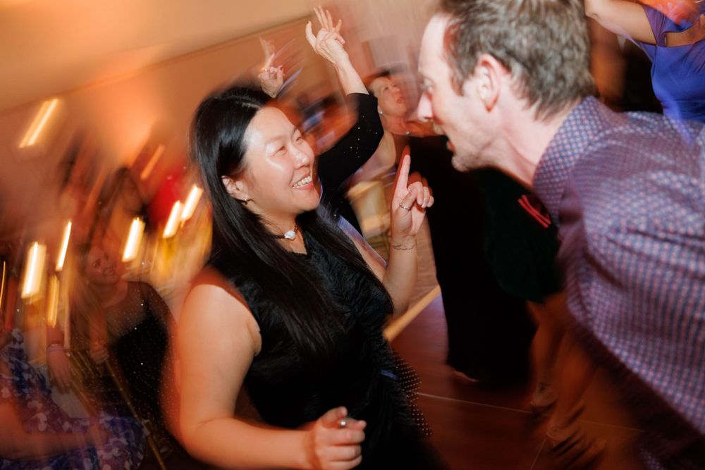 Energetic dance floor moment captured in motion blur at a wedding reception.