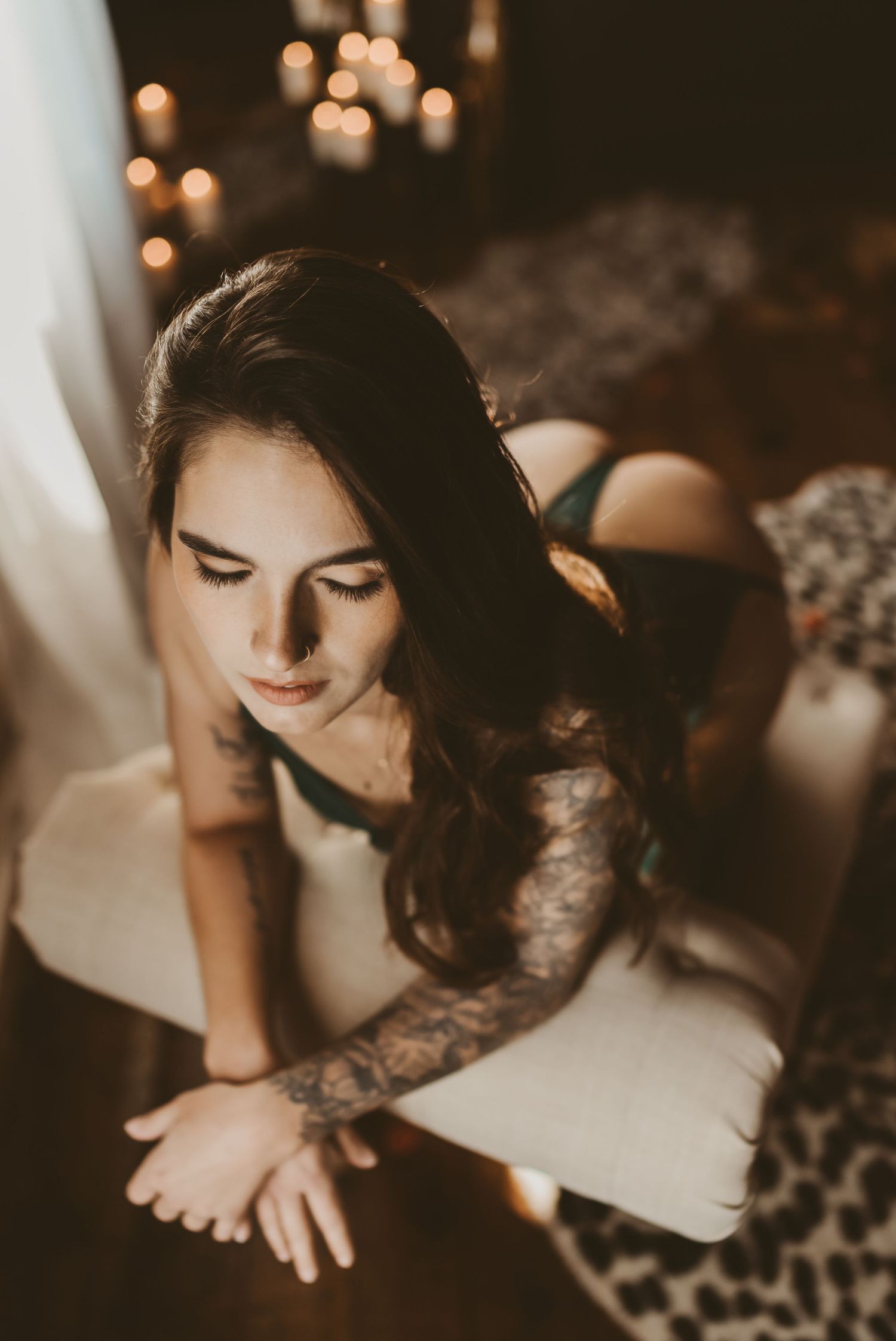 Moody boudoir portrait with candlelight and lace details.
