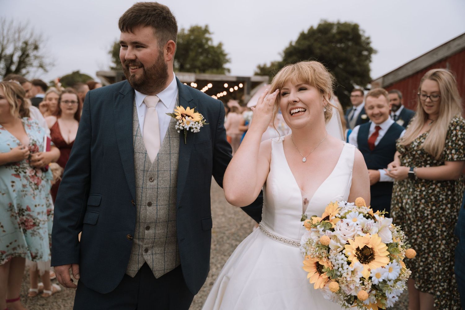 Candid outdoor wedding photo showing joyful reactions during ceremony.