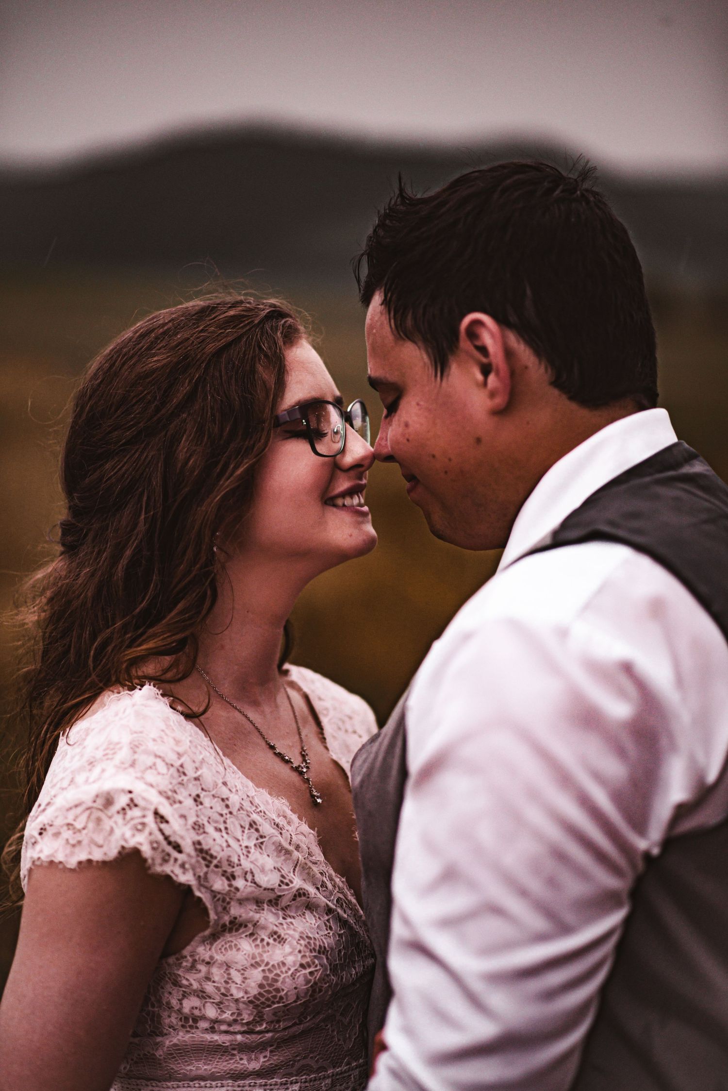 Intimate wedding portrait against scenic mountain backdrop at sunset.