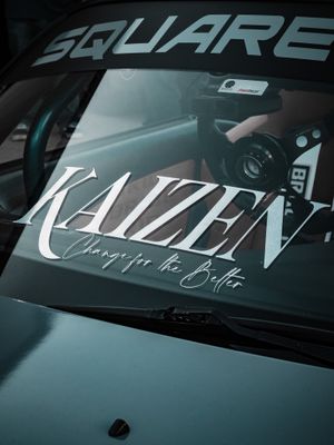Picture of car windshield with a sticker that says "KAIZEN"