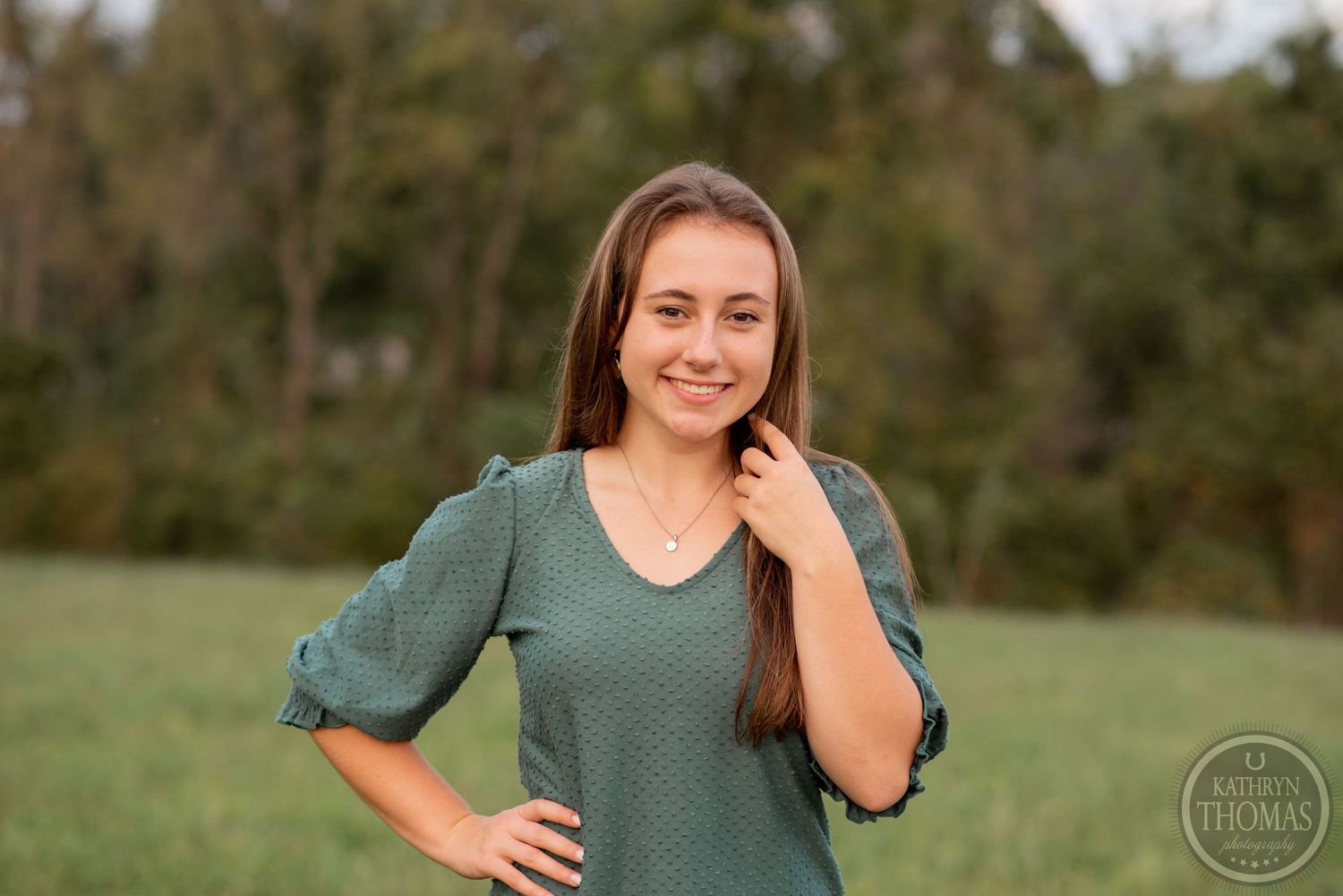 Outdoor portrait featuring a green textured top against a natural field background.