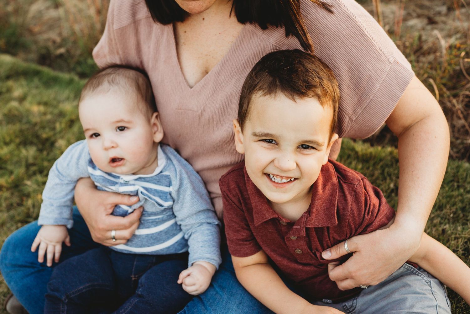 yearly family photos of two boys taking holiday pictures with their mom at a park  wearing maroon shirt and mauve