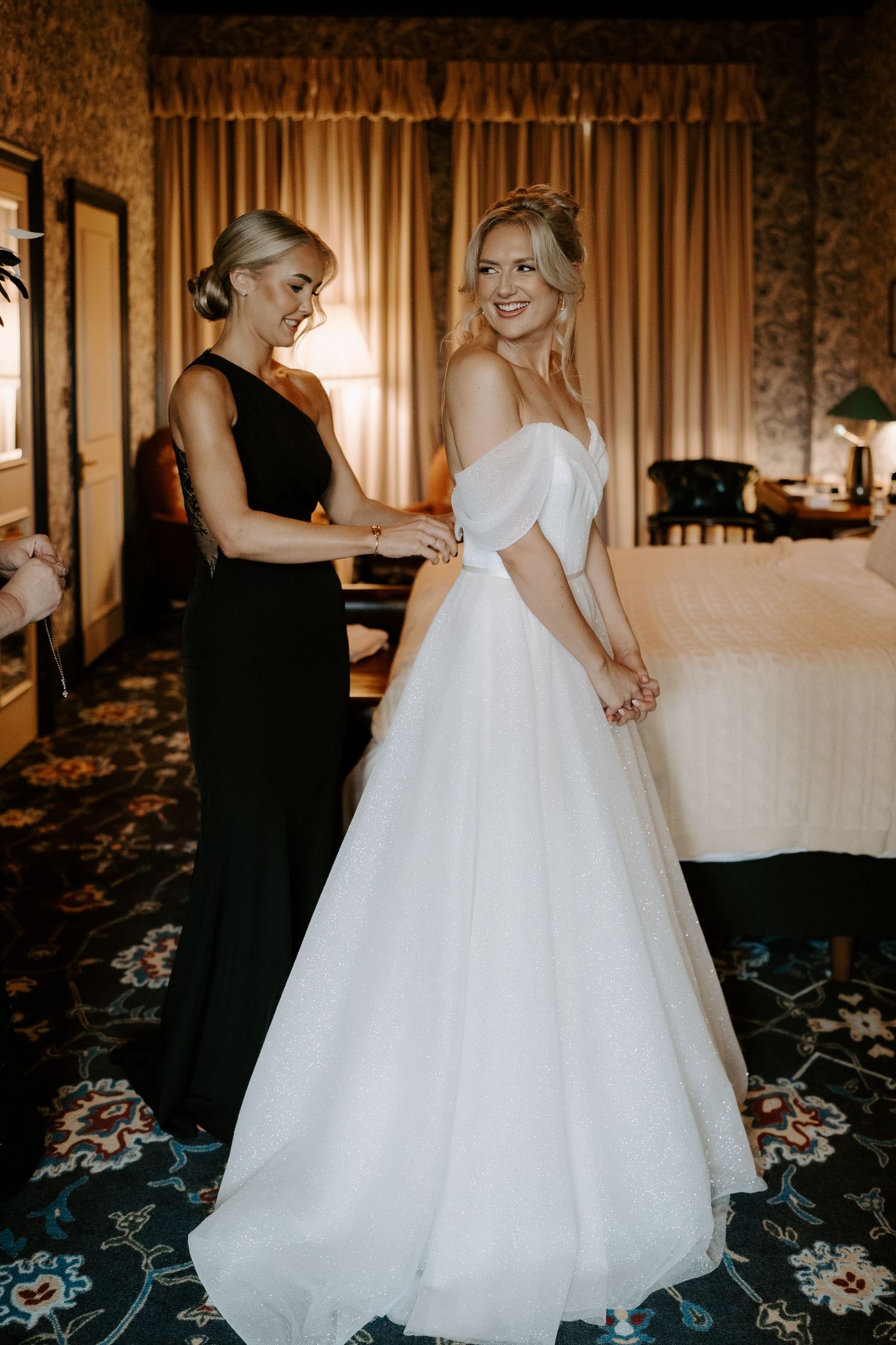 bridesmaids fastening brides dress at the Randolph hotel in Oxford