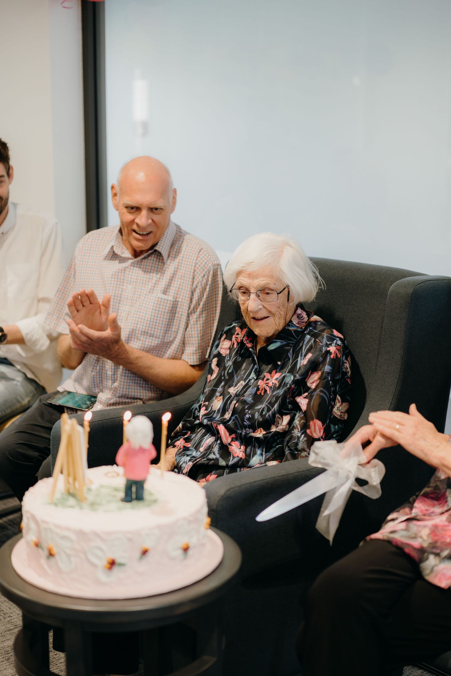 woman celebrates 100th birthday with family and cake with replica of one of her famous paintings