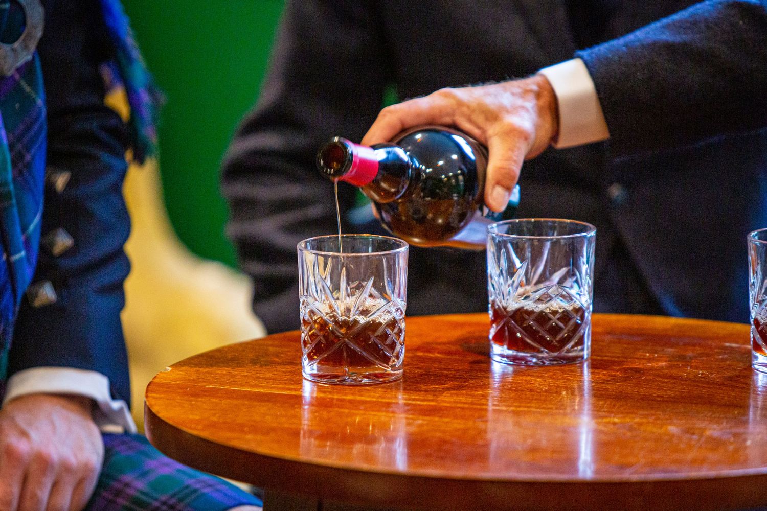 Close-up shots of drinks being poured at wooden bar during reception.