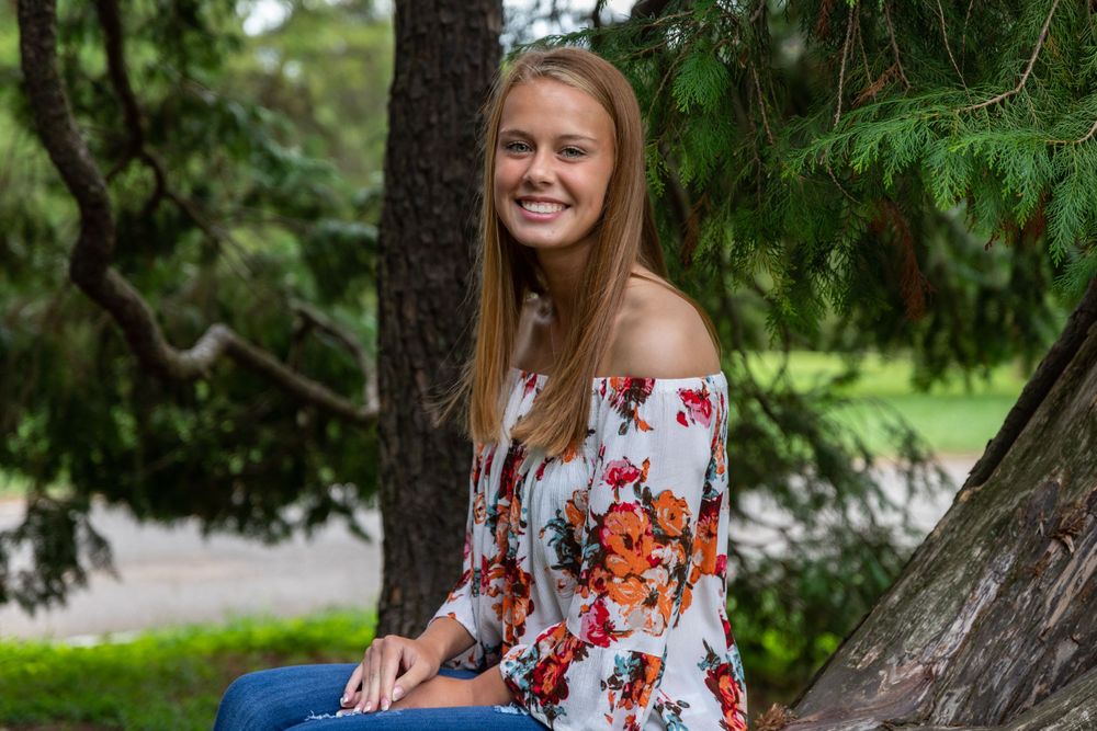Outdoor portrait session in a natural setting with pine trees.
