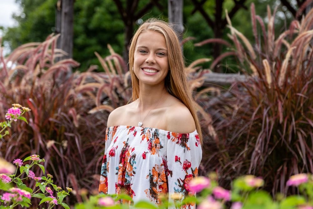 Portrait session among colorful garden flowers and foliage.